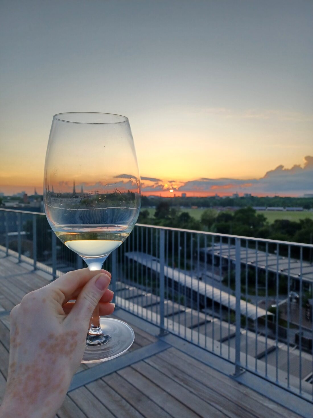 A glass of wine held against warm evening light
